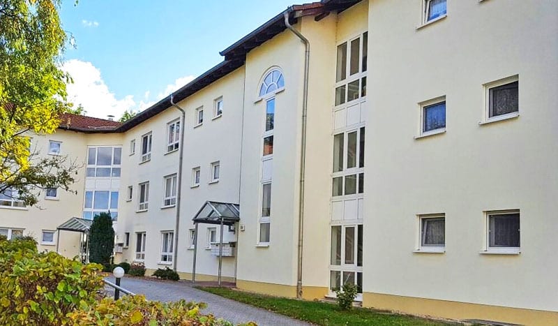 Wohngebäude des Wohnparks mit hellen Fassaden und Grünanlage