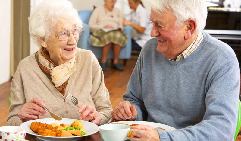 Seniorenpaar genießt gemeinsam eine Mahlzeit im Speiseraum